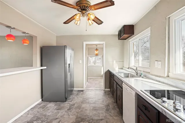 a kitchen with stainless steel appliances granite countertop a sink and a refrigerator