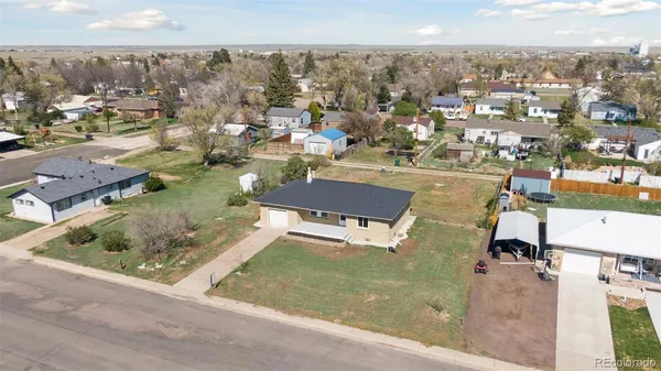 an aerial view of a residential houses with outdoor space and parking