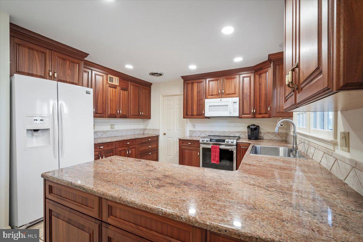 2 Candlelight Court Potomac, MD 20854 - Photo 11 of 58 a kitchen with stainless steel appliances granite countertop a sink refrigerator and cabinets