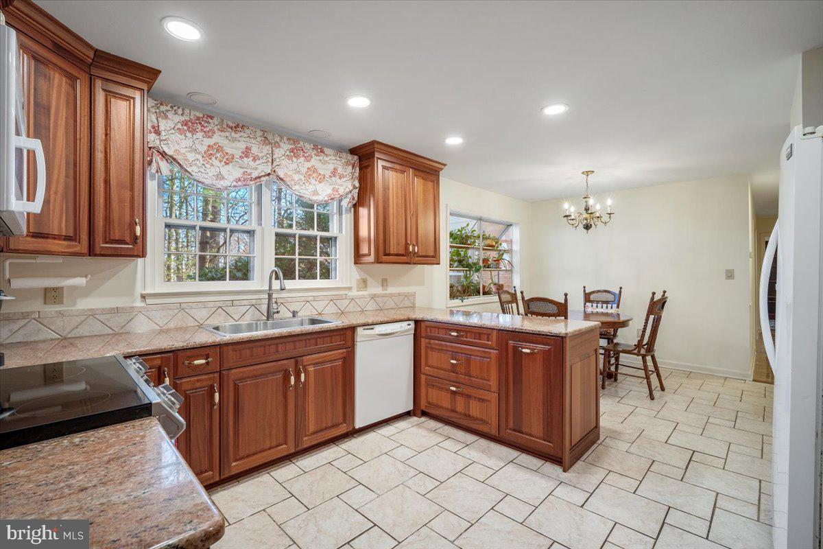 2 Candlelight Court Potomac, MD 20854 - Photo 12 of 58 a large kitchen with kitchen island granite countertop a sink and dishwasher wooden cabinets with granite countertops