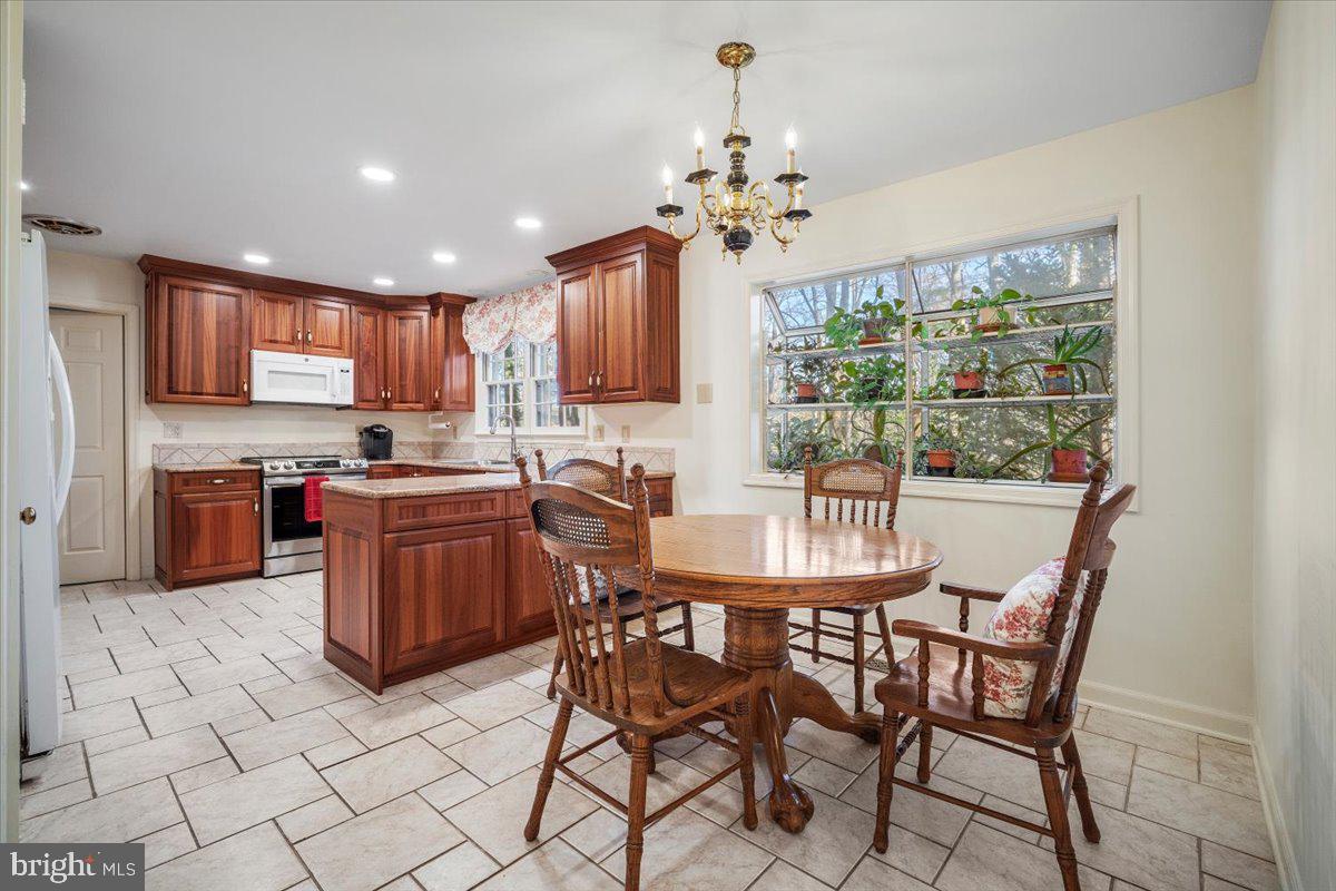 2 Candlelight Court Potomac, MD 20854 - Photo 14 of 58 a kitchen with a dining table chairs and refrigerator