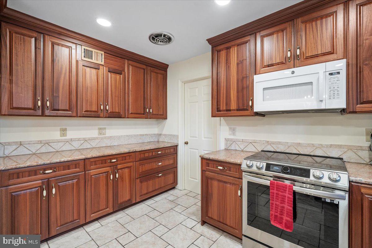 2 Candlelight Court Potomac, MD 20854 - Photo 9 of 58 a kitchen with stainless steel appliances granite countertop cabinets and a stove top oven