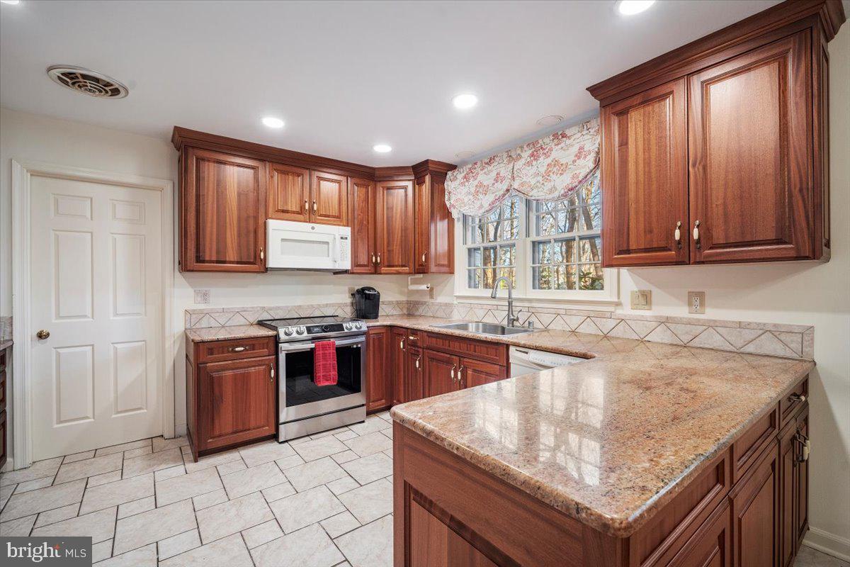 2 Candlelight Court Potomac, MD 20854 - Photo 10 of 58 a kitchen with stainless steel appliances granite countertop a stove sink and cabinets
