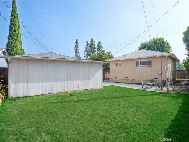 a view of a backyard with plants and a small cabin