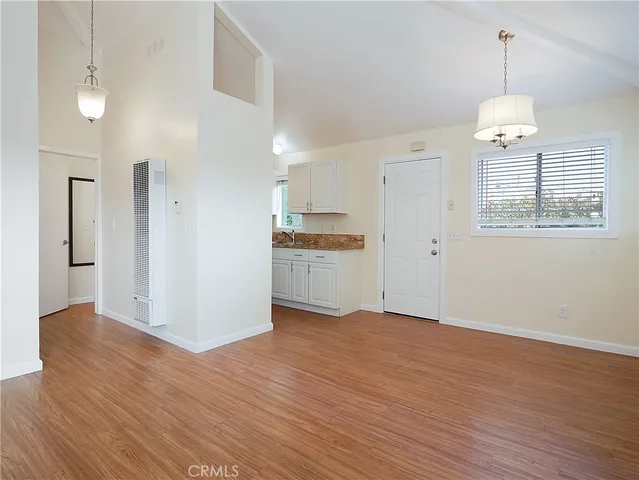 a view of a kitchen with wooden floor and a kitchen