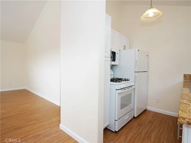 a kitchen with cabinets and wooden floor