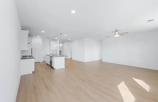 a kitchen with a stove a sink a refrigerator and a wooden floor