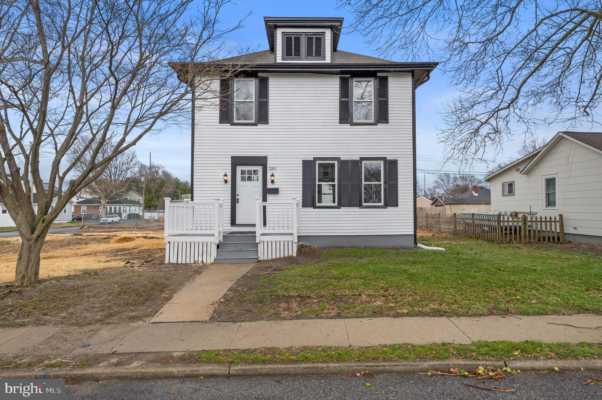 261 B Street Carneys Point, NJ 08069 - Photo 30 of 32 a view of a white house with large windows and a yard