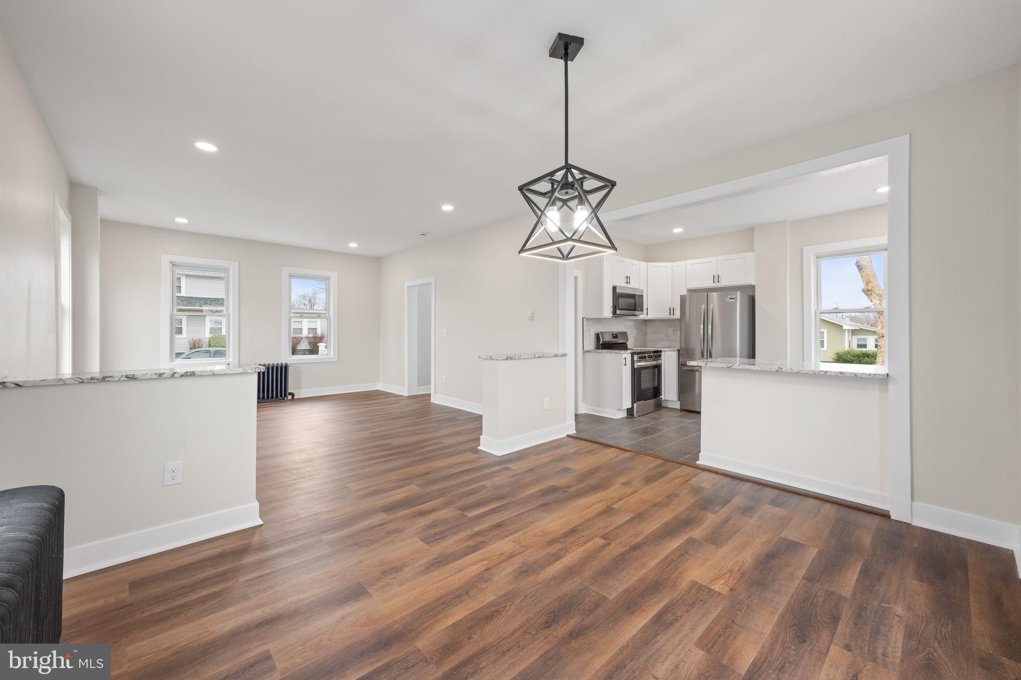 261 B Street Carneys Point, NJ 08069 - Photo 9 of 32 a view of a kitchen with a refrigerator wooden floor and a chandelier