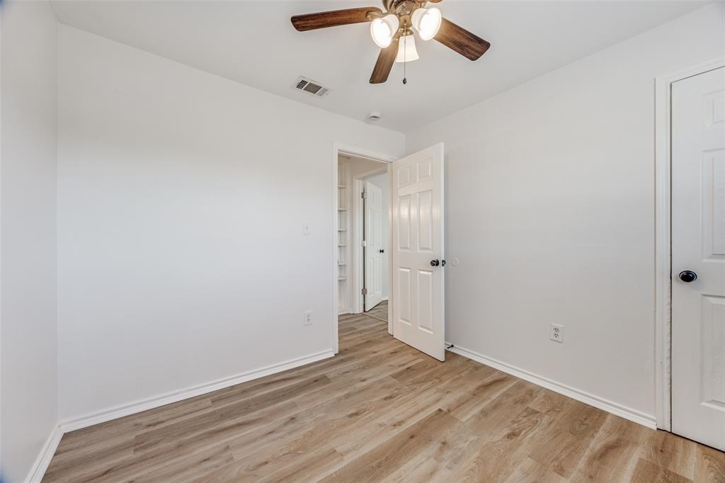 1382 Us Highway Denison, TX 75021 - Photo 18 of 25 an empty room with wooden floor chandelier fan and closet area