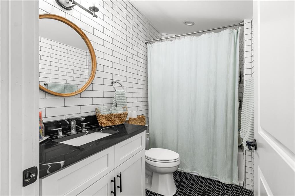 6120 Cardinal Drive Gainesville, GA 30506 - Photo 26 of 34 a bathroom with a sink a toilet and shower curtain