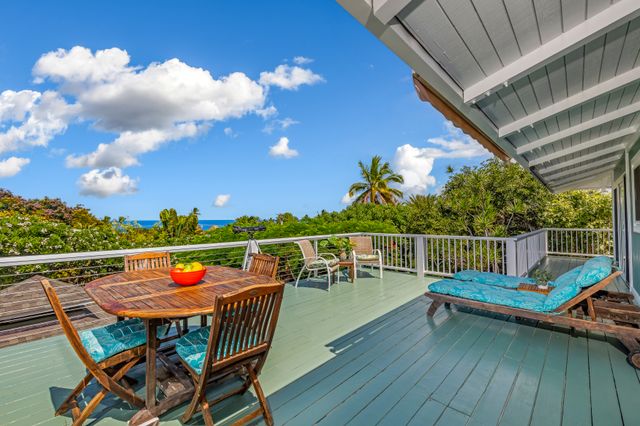 a view of a chairs and table on the wooden roof deck