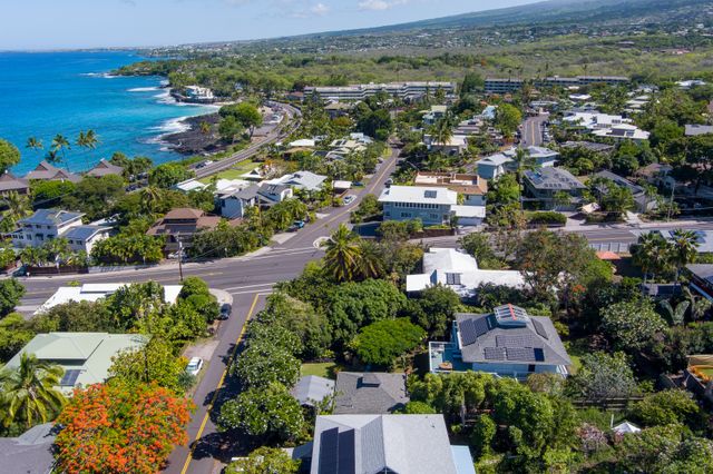 an aerial view of residential houses with outdoor space and trees