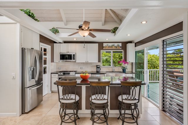 a kitchen with stainless steel appliances granite countertop a stove a refrigerator a oven a sink with a dining table and chairs