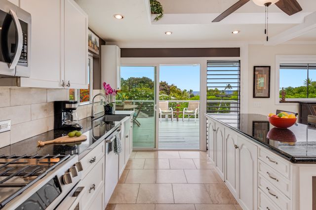 a kitchen with stainless steel appliances a stove top oven a sink a counter space and a window