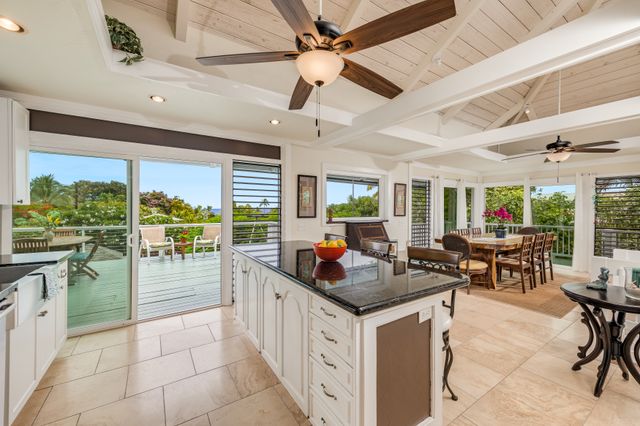 a kitchen with stainless steel appliances kitchen island granite countertop a table chairs and a view of living room