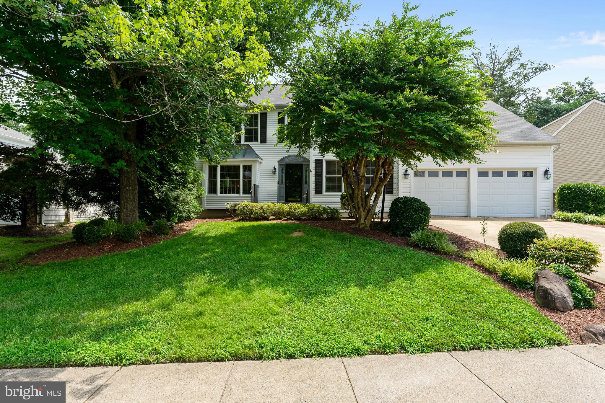 13824 Springstone Drive Clifton, VA 20124 - Photo 47 of 56 a front view of a house with a garden and trees