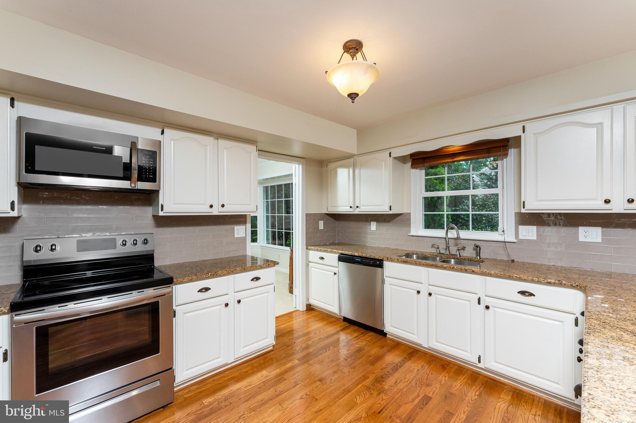 13824 Springstone Drive Clifton, VA 20124 - Photo 6 of 56 a kitchen with a sink stove and microwave