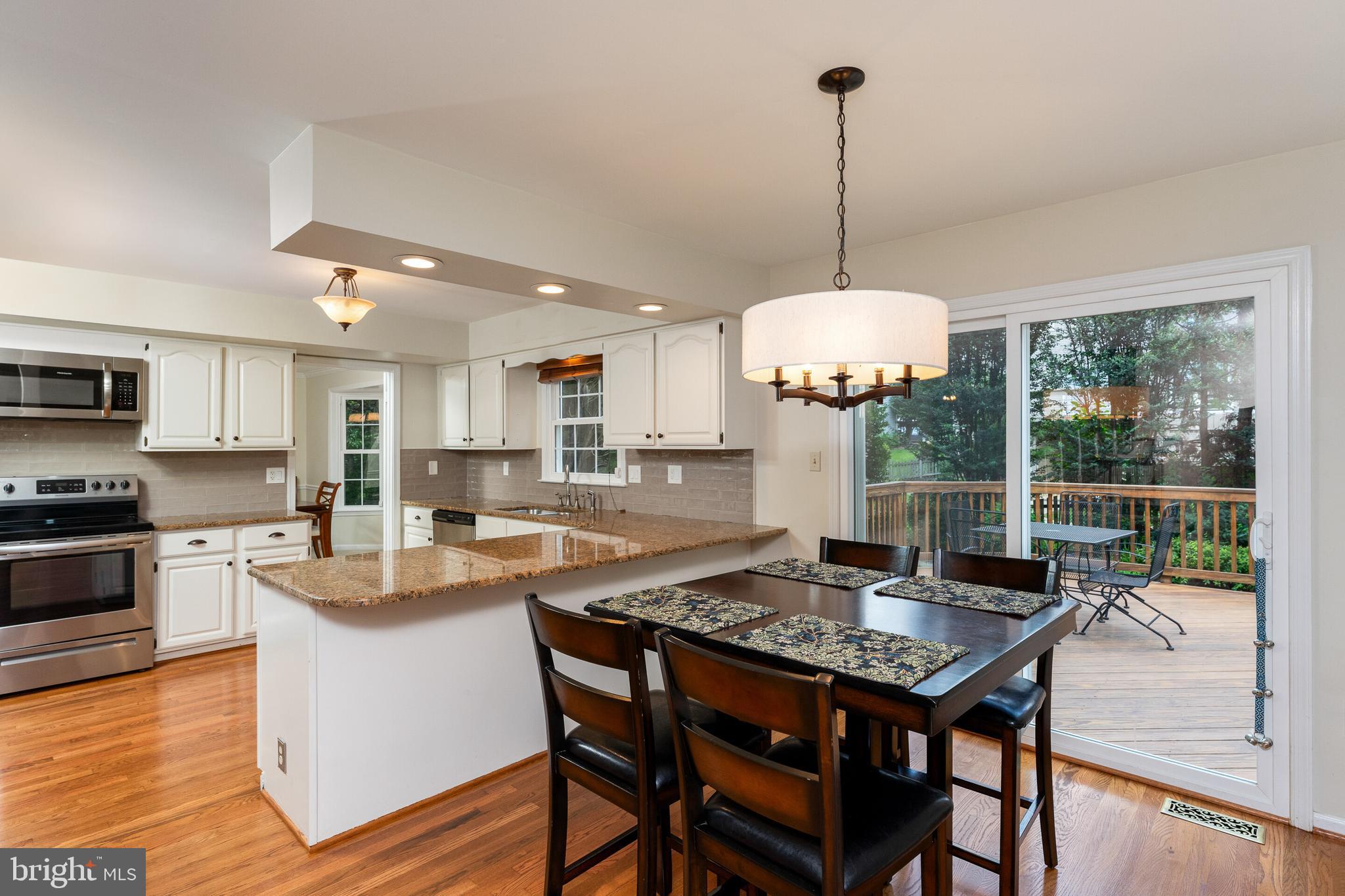 13824 Springstone Drive Clifton, VA 20124 - Photo 8 of 56 a kitchen with stainless steel appliances granite countertop a stove a kitchen island a table and chairs