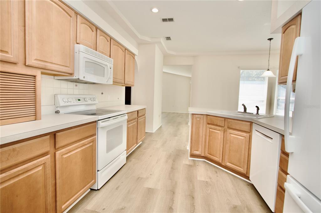 8056 Floral Drive Spring Hill, FL 34607 - Photo 12 of 29 a large white kitchen with stainless steel appliances
