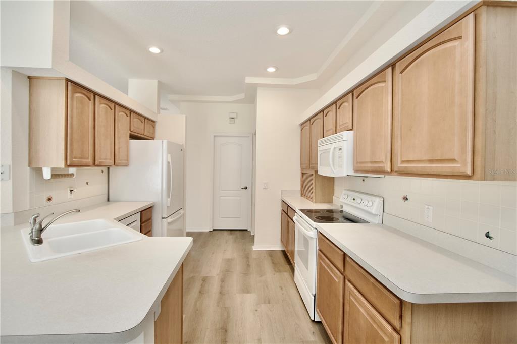 8056 Floral Drive Spring Hill, FL 34607 - Photo 14 of 29 a kitchen with a sink stove and cabinets