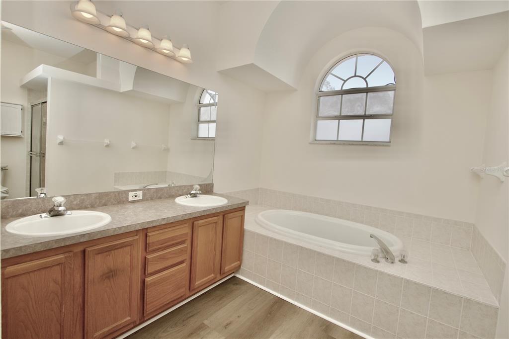 8056 Floral Drive Spring Hill, FL 34607 - Photo 17 of 29 a bathroom with a granite countertop sink mirror and bathtub