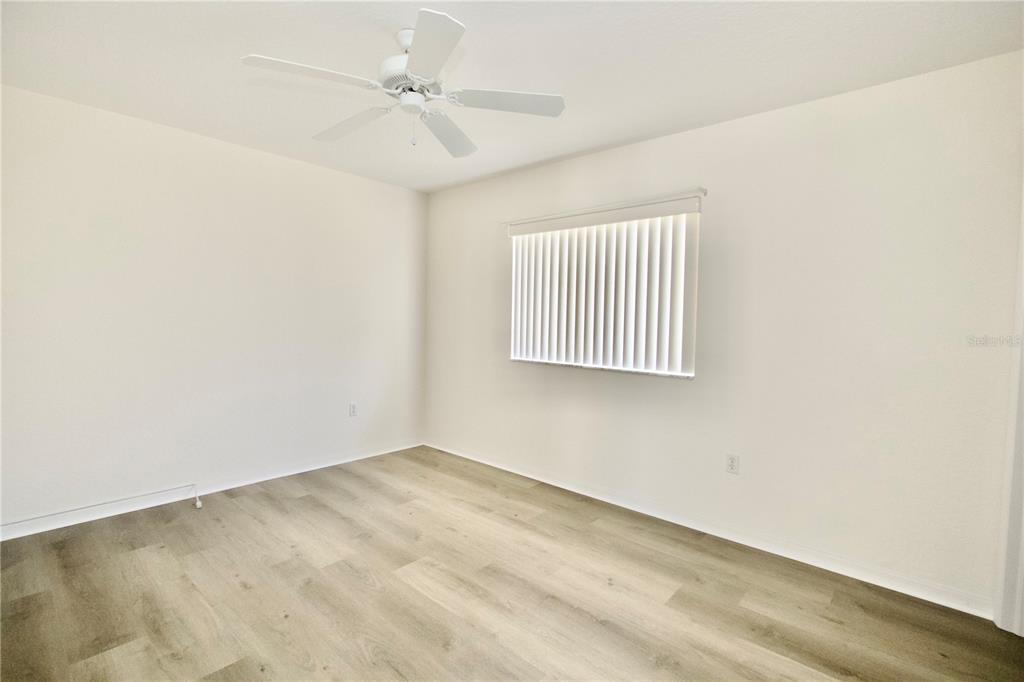8056 Floral Drive Spring Hill, FL 34607 - Photo 23 of 29 an empty room with windows and fan
