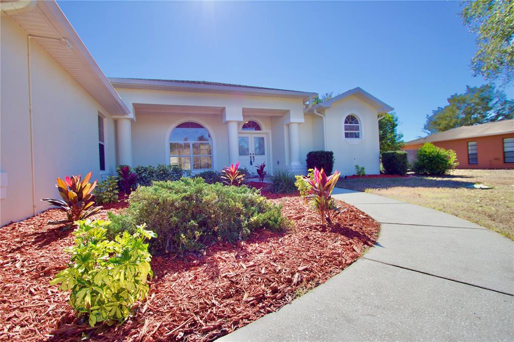 8056 Floral Drive Spring Hill, FL 34607 - Photo 7 of 29 a front view of a house with a yard