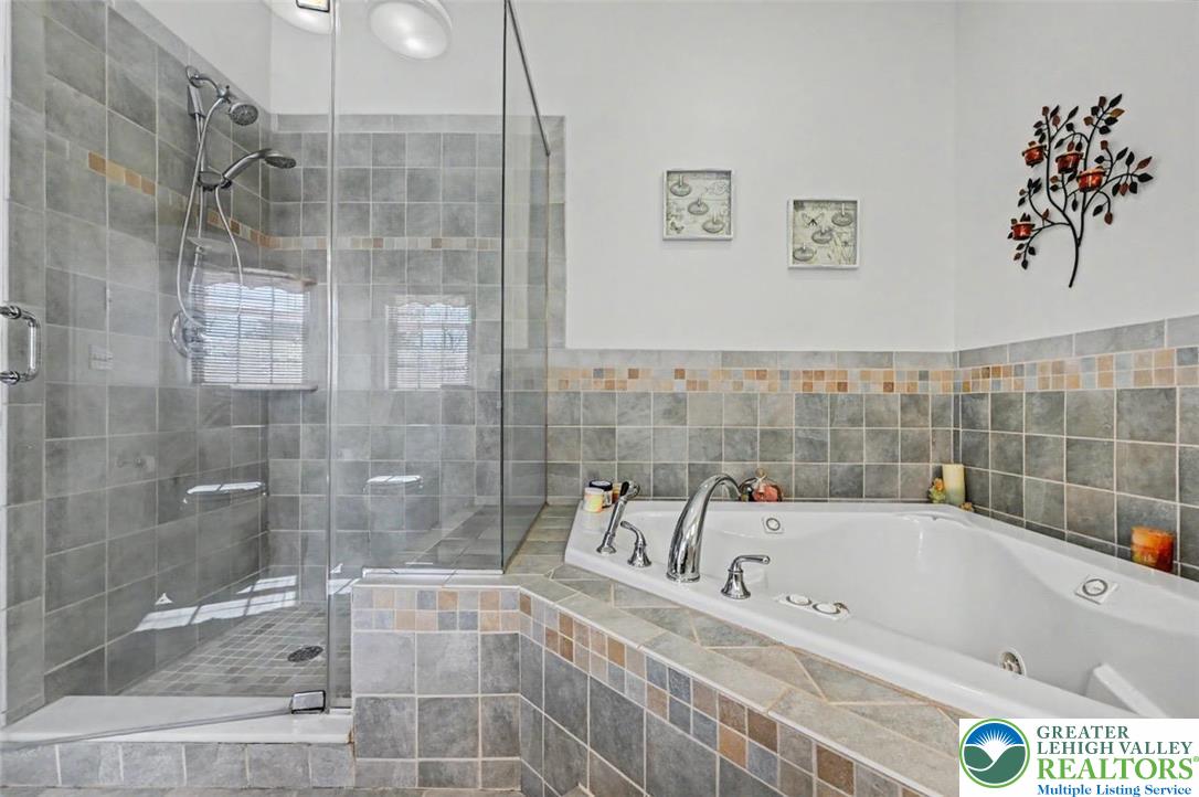 112 Michaels Run Road Stroudsburg, PA 18360 - Photo 38 of 69 The Primary Bath features a jetted corner tub with tile surround and a large shower with glass enclosure.