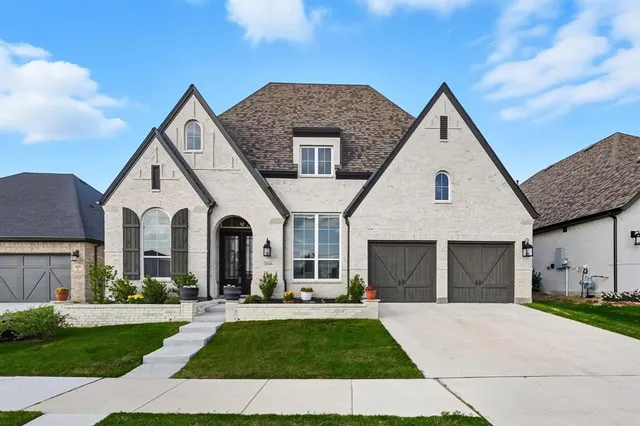 a front view of a house with a garden and yard