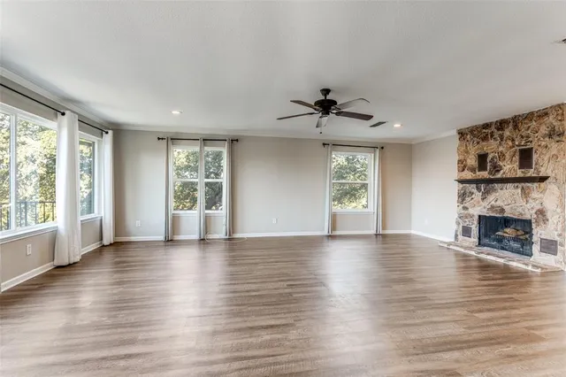 a view of an empty room with window and wooden floor