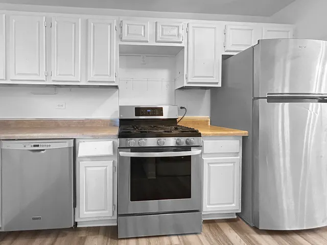 a kitchen with stainless steel appliances granite countertop a refrigerator stove and cabinets