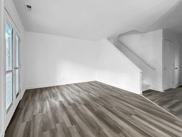 a view of empty room with wooden floor