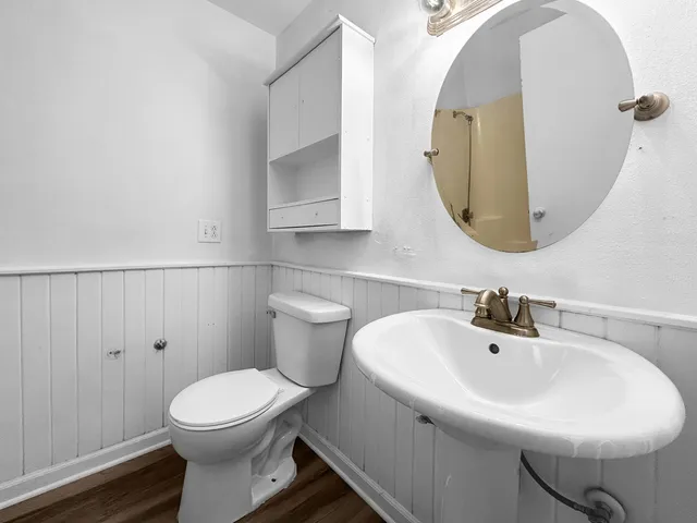 a bathroom with a toilet sink and mirror