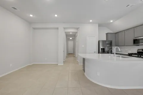 a large white kitchen with kitchen island a sink a stove and a window