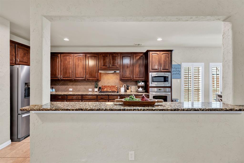 1701 Meadow Ranch Road McKinney, TX 75071 - Photo 14 of 40 a kitchen with stainless steel appliances granite countertop a sink a stove and a refrigerator