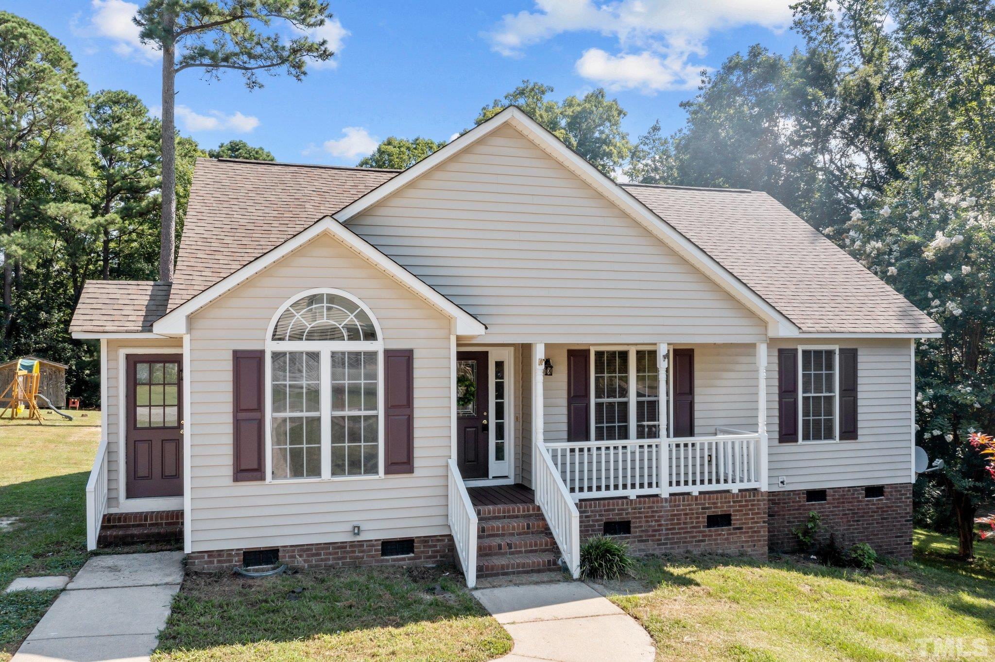 302 Laurel Drive Smithfield, NC 27577 - Photo 1 of 38 a view of a white house with potted plants and a yard