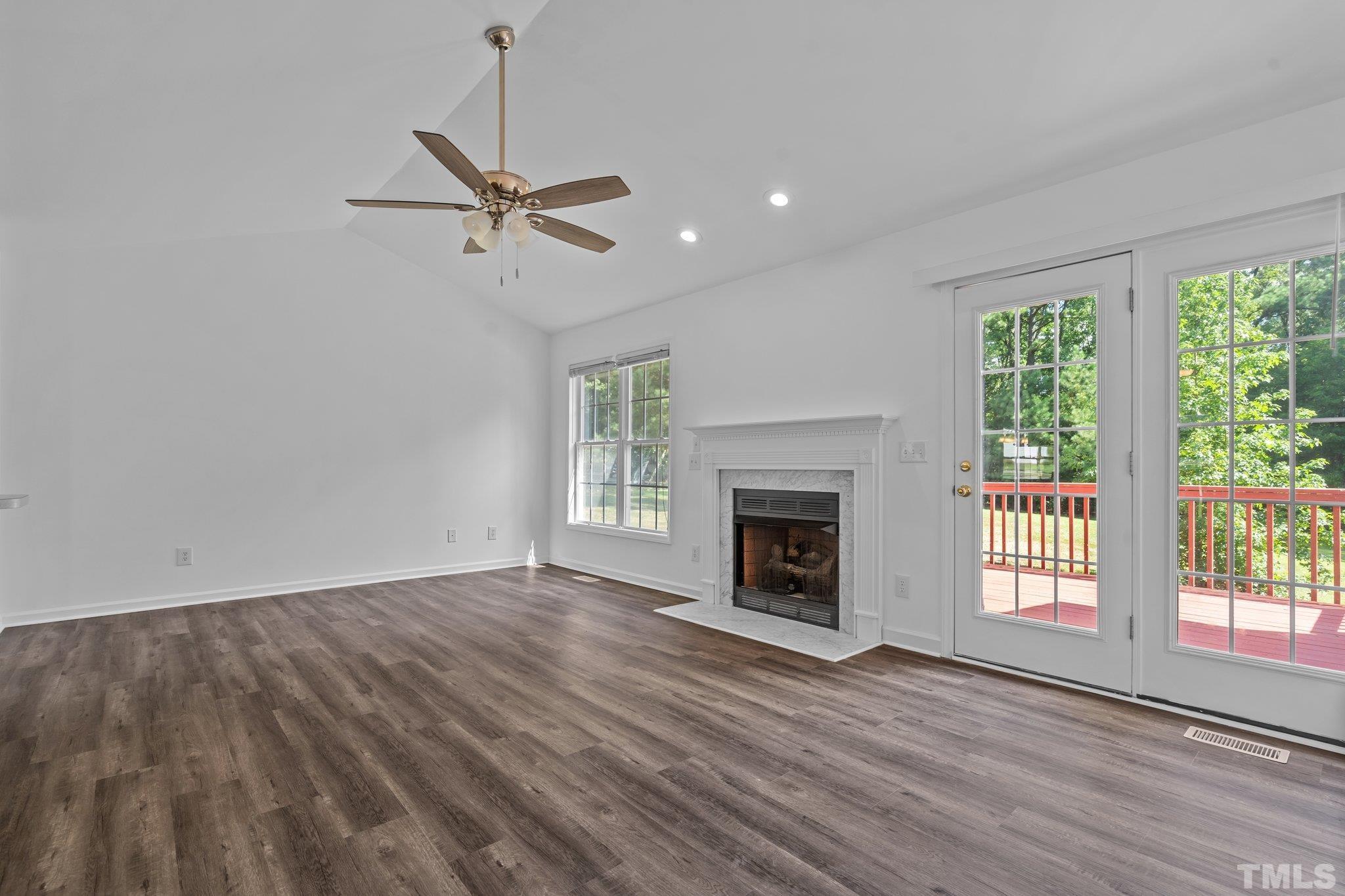 302 Laurel Drive Smithfield, NC 27577 - Photo 15 of 38 an empty room with windows fireplace and wooden floor