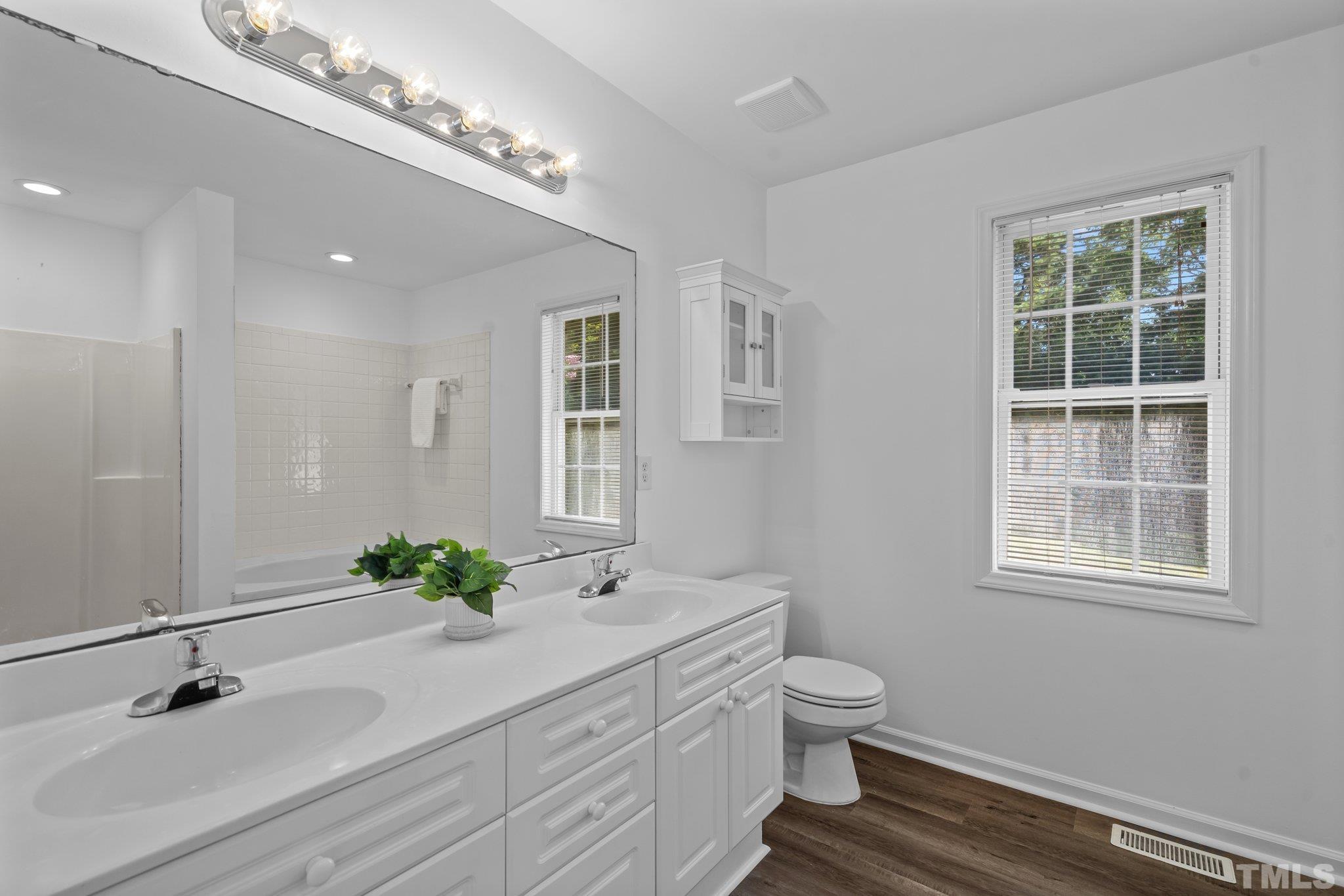 302 Laurel Drive Smithfield, NC 27577 - Photo 23 of 38 a bathroom with a granite countertop sink a toilet and a mirror