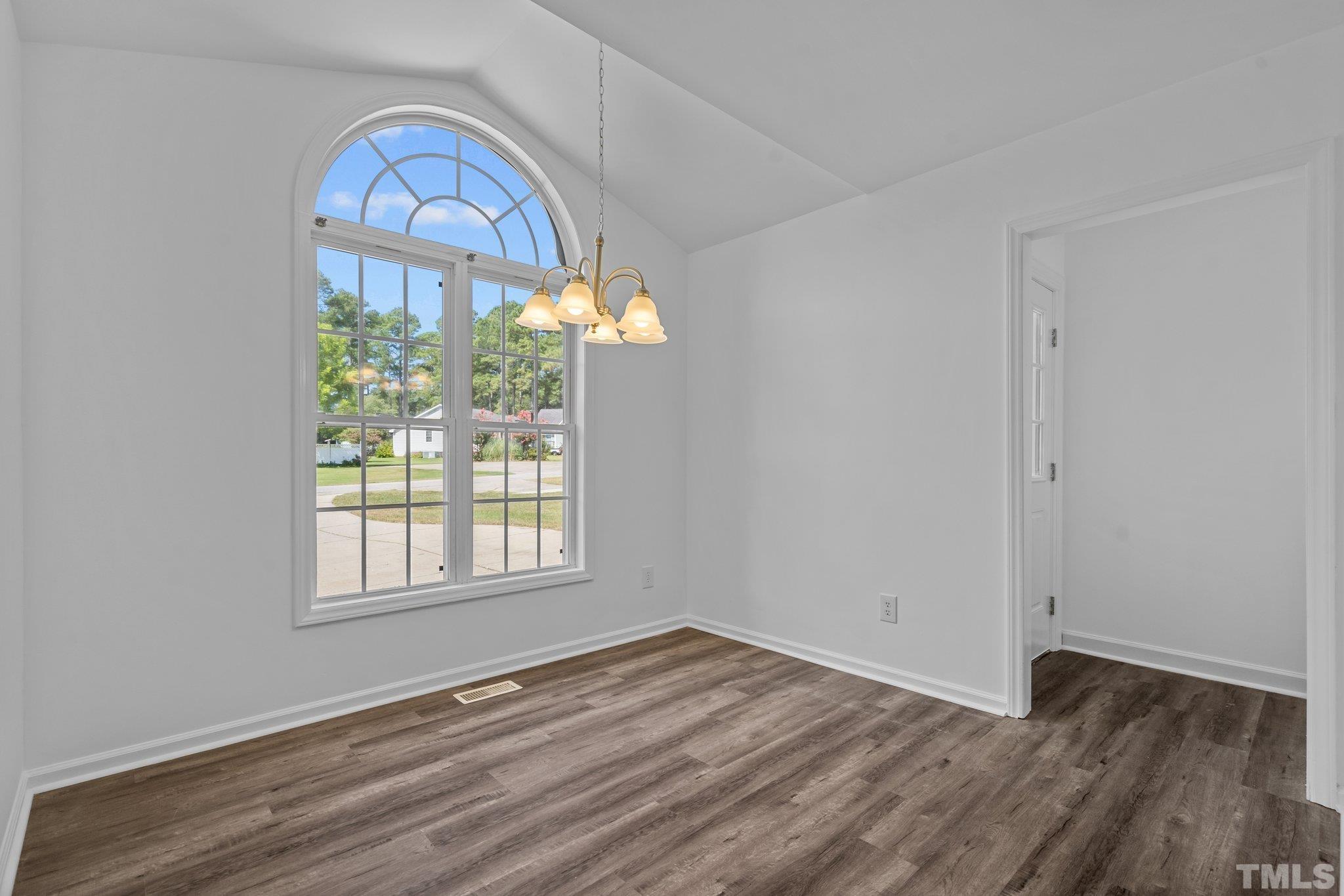 302 Laurel Drive Smithfield, NC 27577 - Photo 7 of 38 an empty room with wooden floor windows and a wooden floor