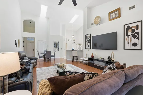 a living room with furniture kitchen view and a flat screen tv
