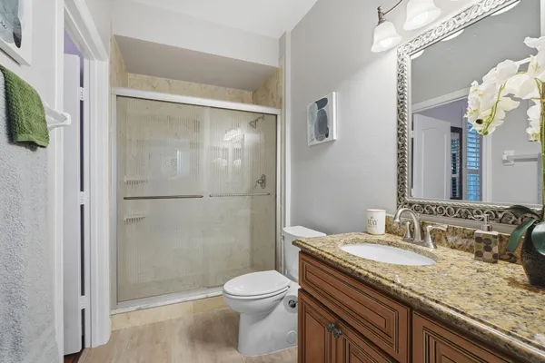 a bathroom with a granite countertop sink toilet and shower