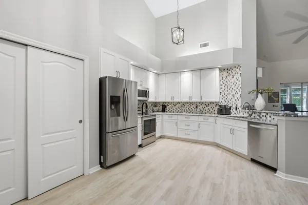 a kitchen with granite countertop stainless steel appliances a refrigerator and cabinets