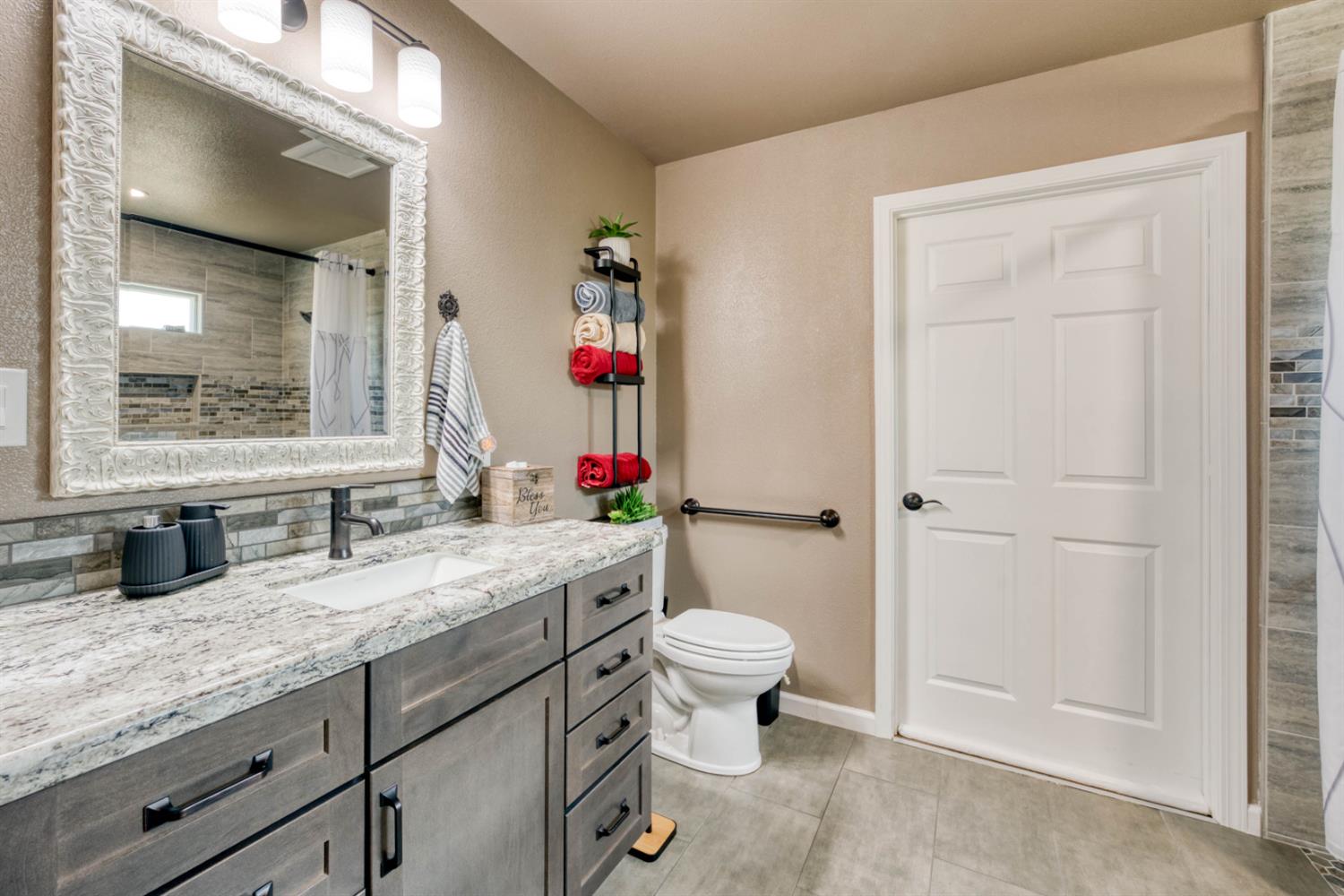 15656 Millerton Road Prather, CA 93651 - Photo 31 of 56 a bathroom with a granite countertop sink mirror vanity and toilet