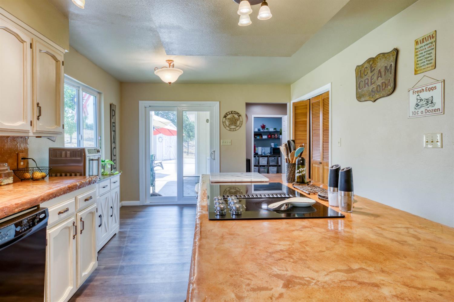 15656 Millerton Road Prather, CA 93651 - Photo 8 of 56 a large kitchen with kitchen island a stove a sink dishwasher and wooden cabinets with wooden floor