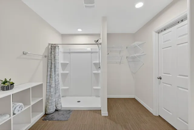 a view of walk in closet with clothes and shoes