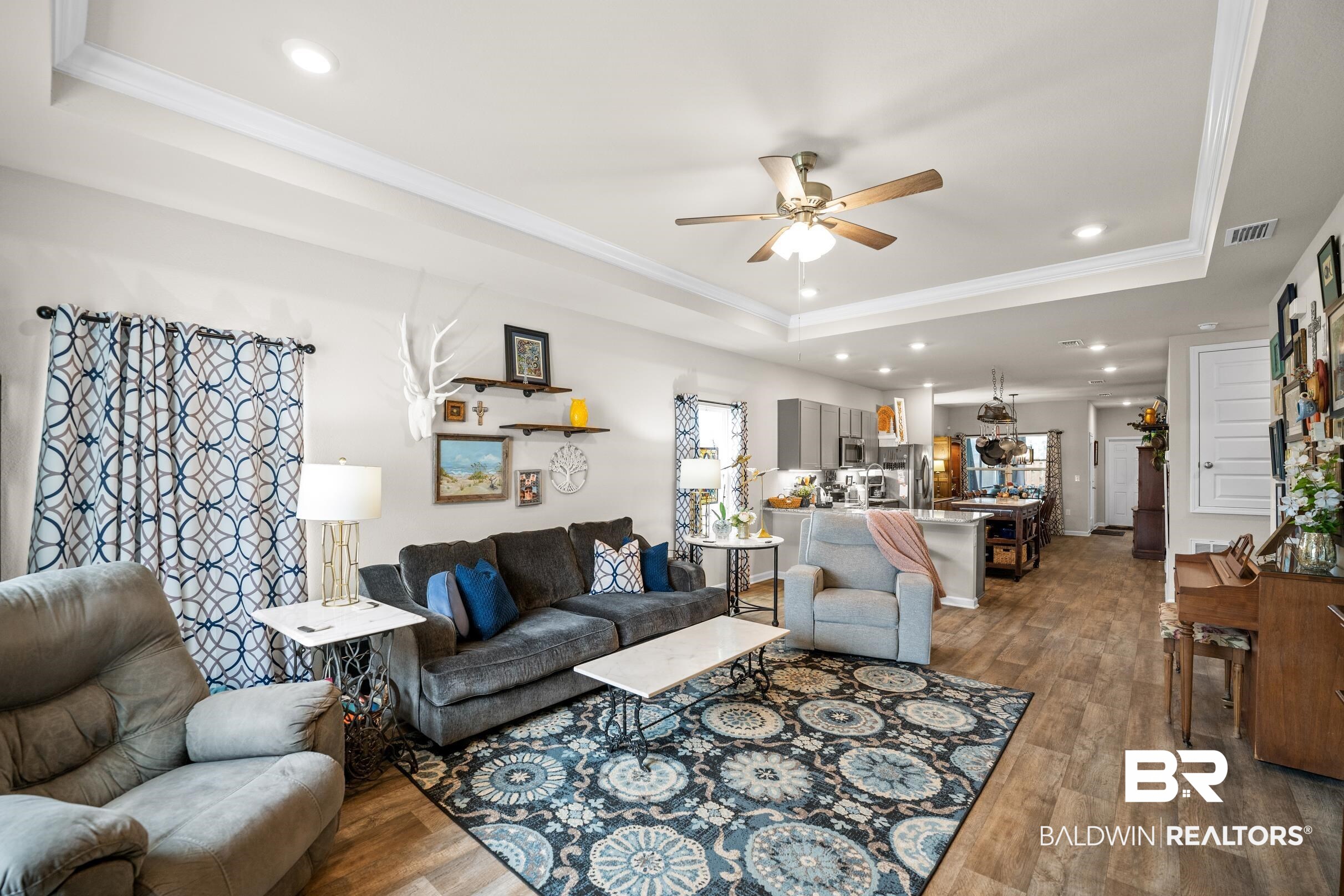24139 Veranda Circle Elberta, AL 36530 - Photo 11 of 40 Living room featuring dark wood-style floors, visible vents, ceiling fan, ornamental molding, and a raised ceiling