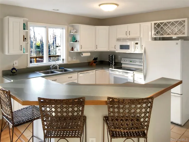 a kitchen with stainless steel appliances granite countertop a sink a stove a counter space and cabinets