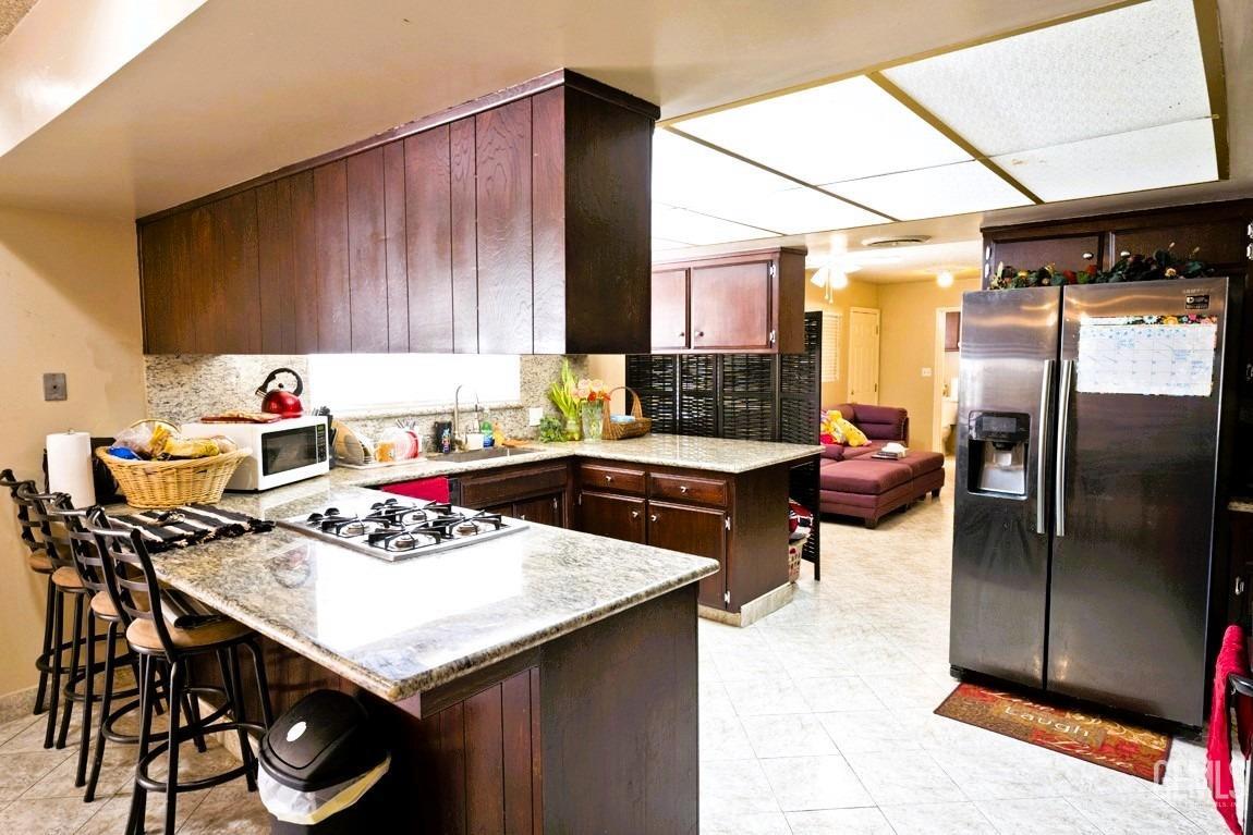 Undisclosed Address Bakersfield, CA 93309 - Photo 11 of 37 a kitchen with a table chairs and a refrigerator