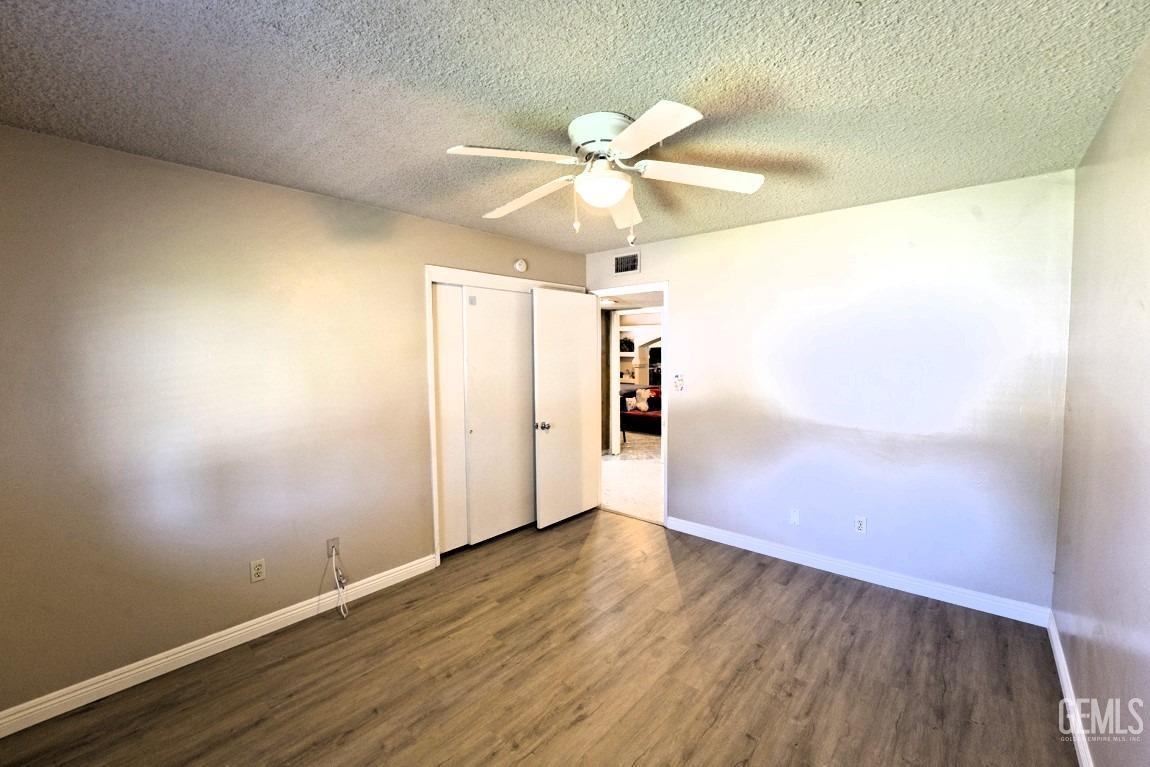 Undisclosed Address Bakersfield, CA 93309 - Photo 18 of 37 an empty room with wooden floor fan and windows
